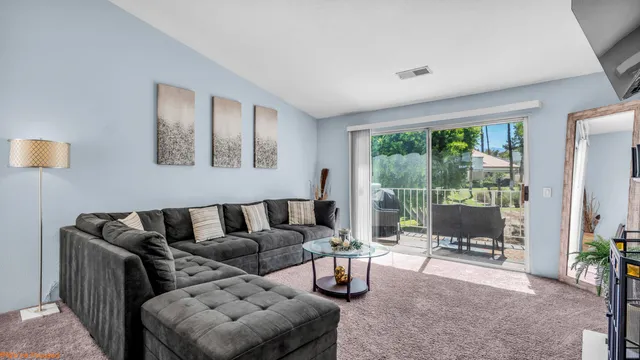 a living room with furniture and a floor to ceiling window