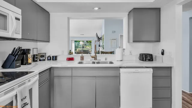 a kitchen with white cabinets and sink