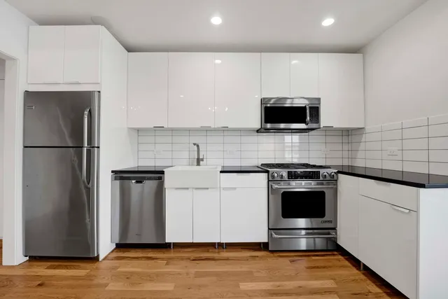 a kitchen with stainless steel appliances a stove a sink a microwave and refrigerator