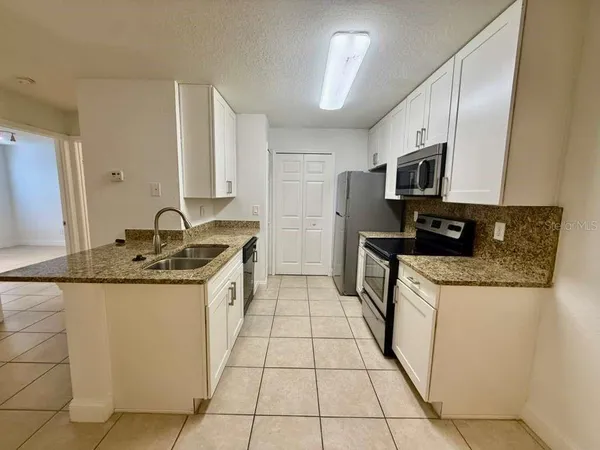a kitchen with stainless steel appliances granite countertop a sink and a stove