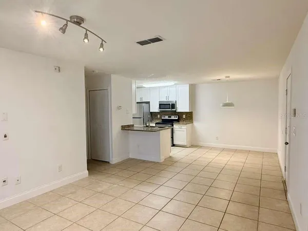 a kitchen with granite countertop a stove a sink and a refrigerator