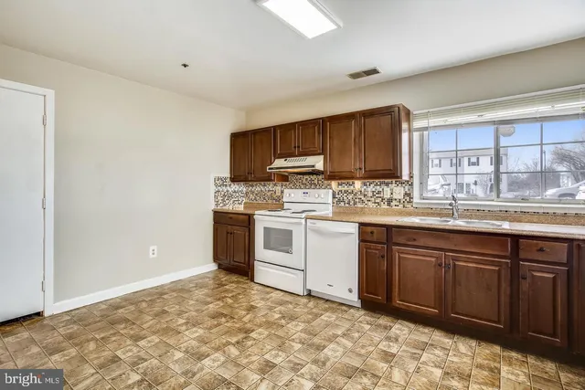 a kitchen with granite countertop a stove top oven sink and cabinets