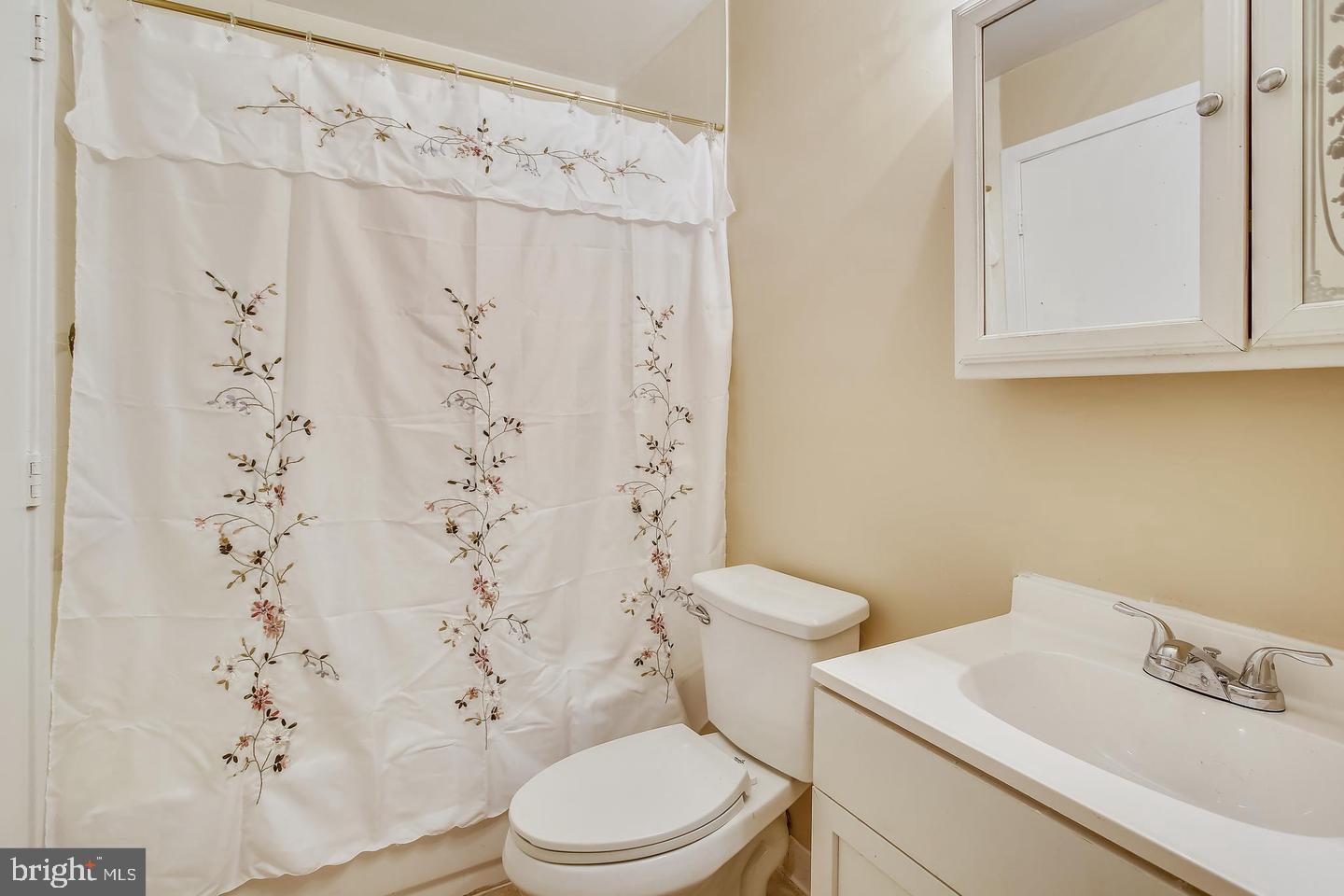 1670 Brooksquare Drive, Unit 54 Capitol Heights, MD 20743 - Photo 17 of 28 a white toilet sitting next to a white sink and a shower curtain