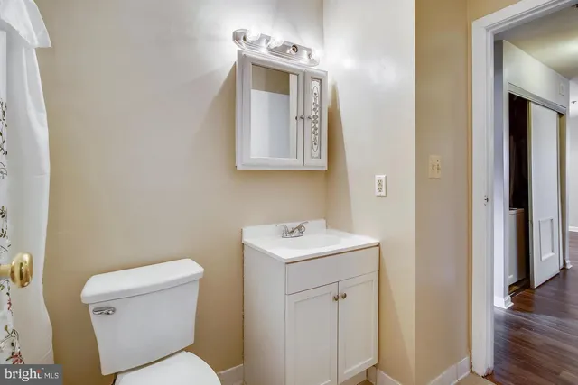 a bathroom with a toilet sink vanity and mirror