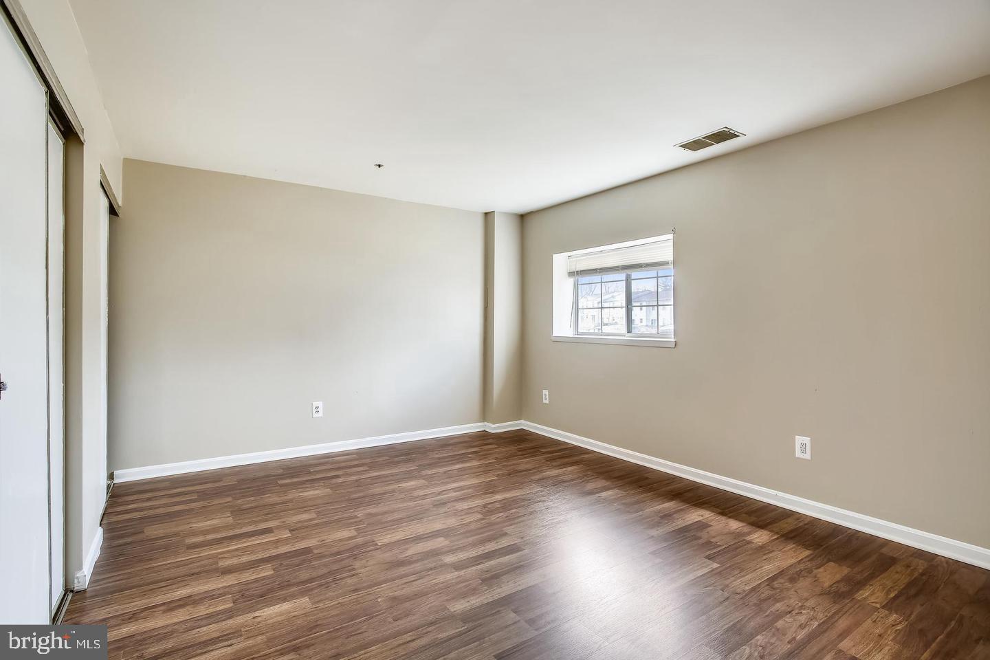 1670 Brooksquare Drive, Unit 54 Capitol Heights, MD 20743 - Photo 19 of 28 a view of an empty room with wooden floor and a window