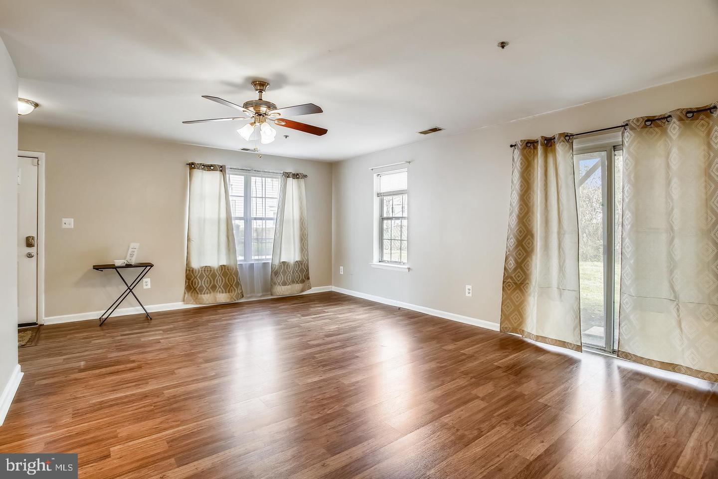 1670 Brooksquare Drive, Unit 54 Capitol Heights, MD 20743 - Photo 6 of 28 an empty room with wooden floor fan and windows