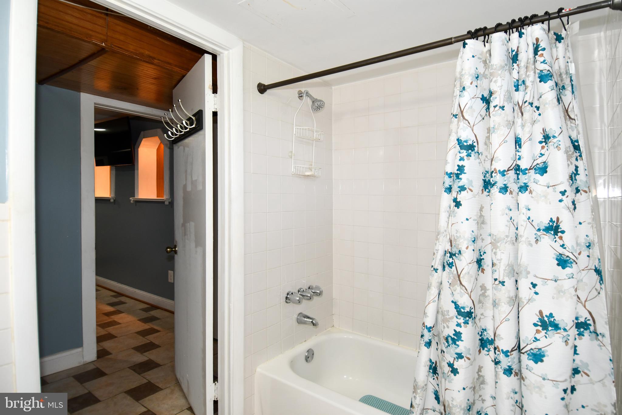 6114 Osborn Road Landover, MD 20785 - Photo 26 of 38 a bathroom with a shower curtain and a bathtub