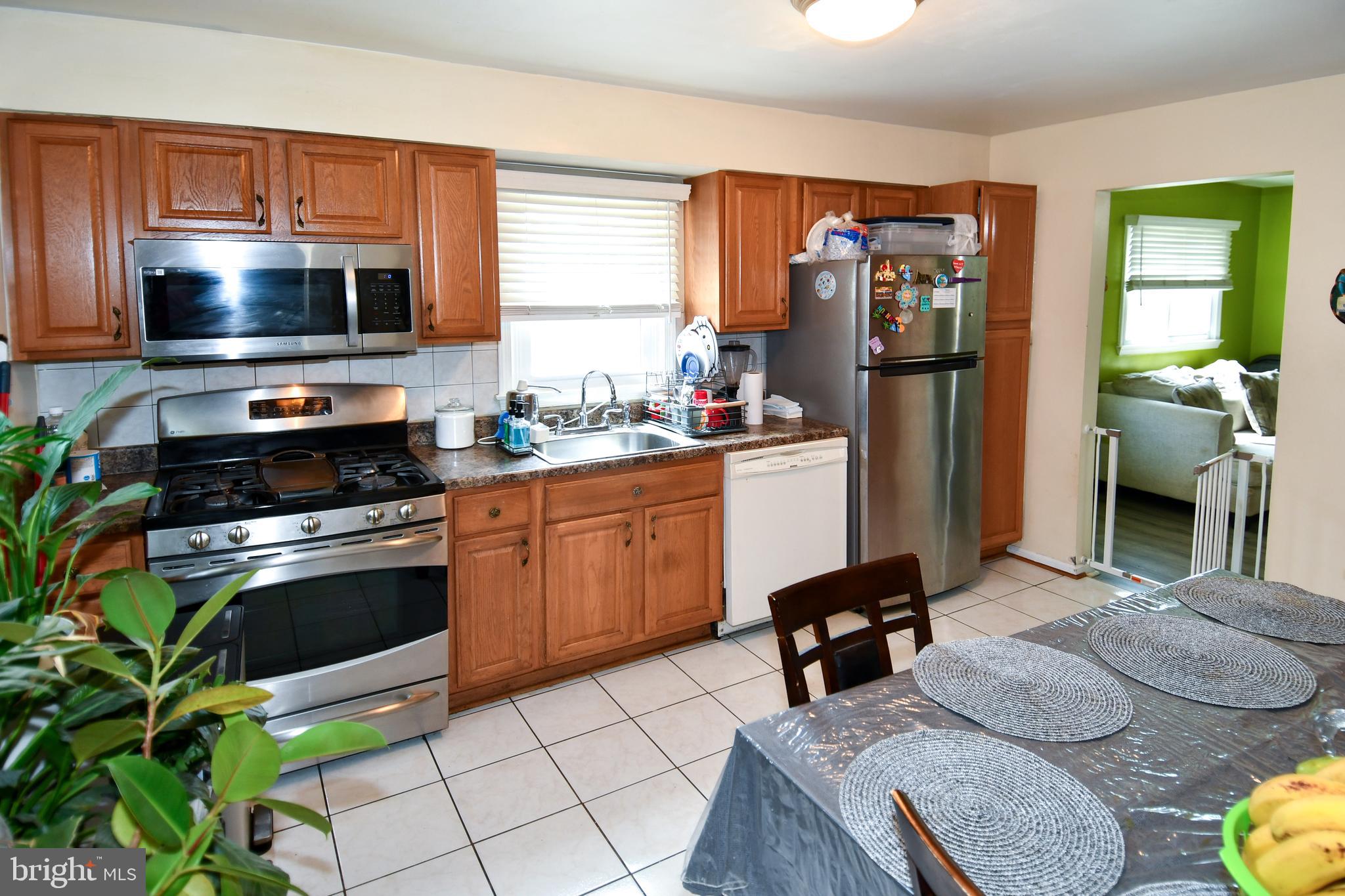 6114 Osborn Road Landover, MD 20785 - Photo 8 of 38 a kitchen with stainless steel appliances a stove refrigerator sink and microwave