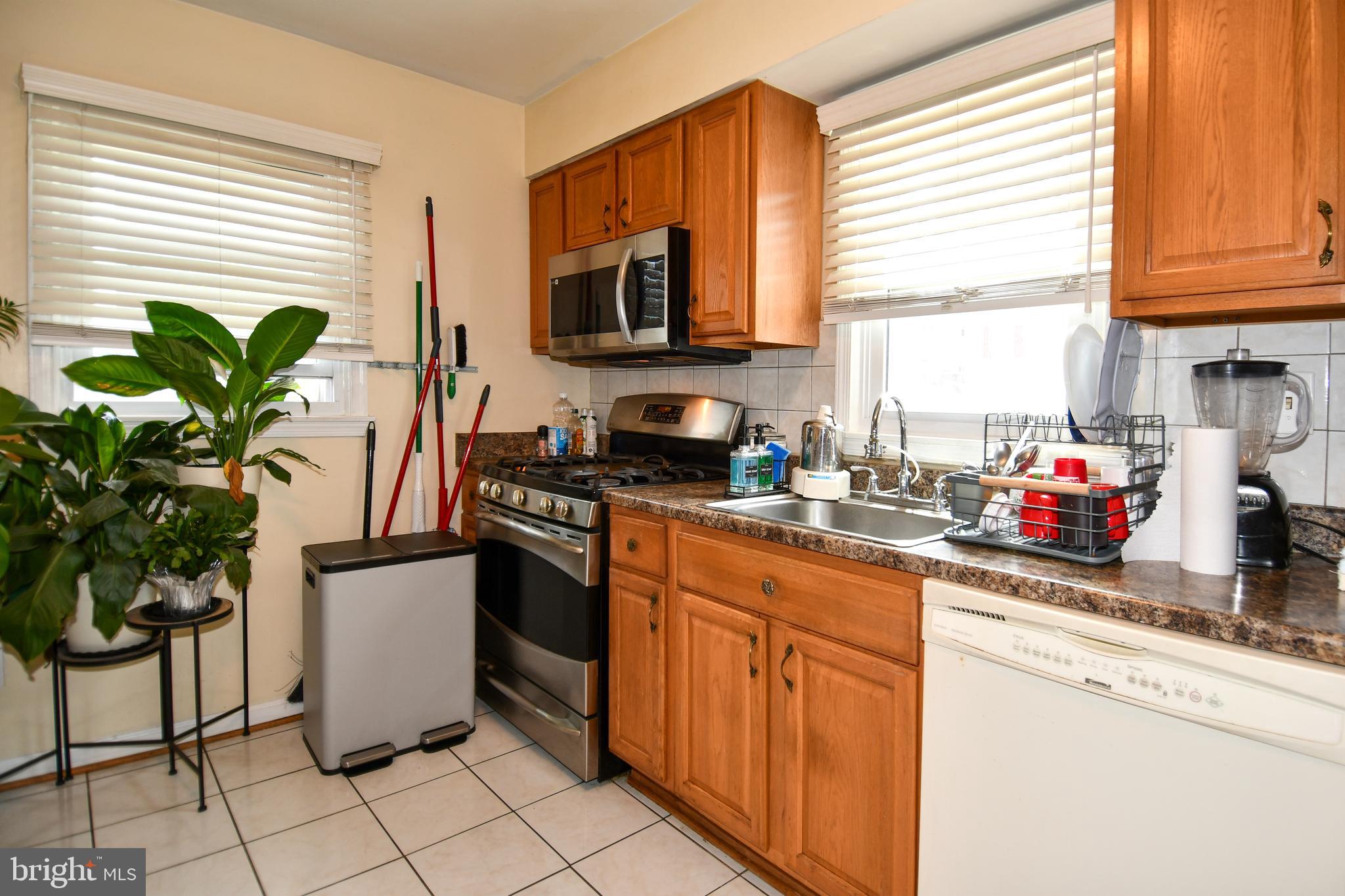 6114 Osborn Road Landover, MD 20785 - Photo 10 of 38 a kitchen with granite countertop a stove a sink and a microwave