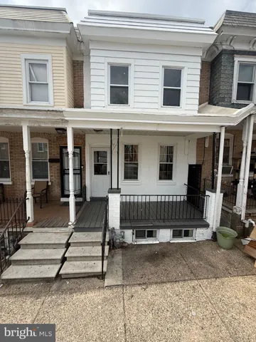 a view of a house with a small yard and wooden floor and fence