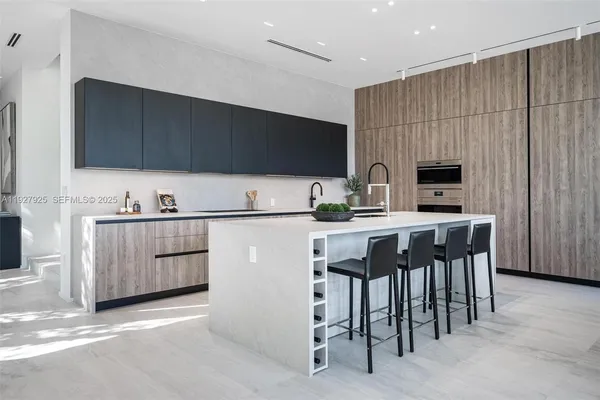 a large living room with stainless steel appliances granite countertop a sink and a large window
