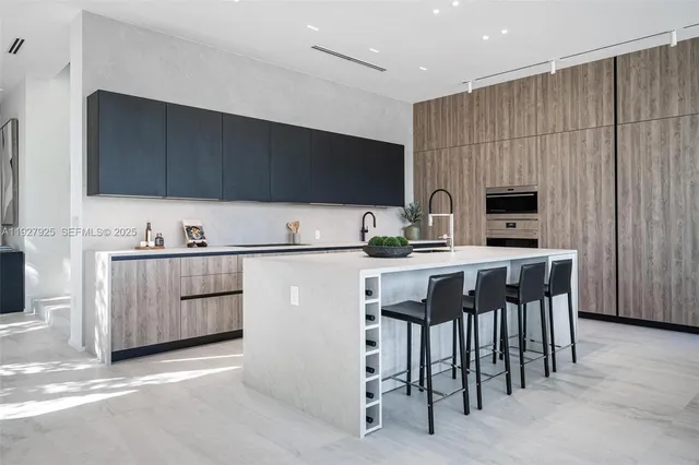 a large living room with stainless steel appliances granite countertop a sink and a large window