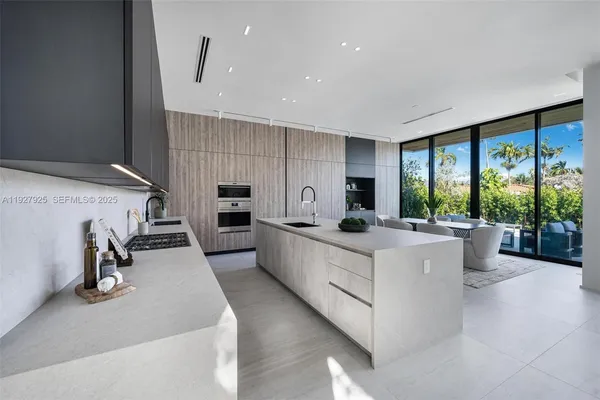 a kitchen with a sink a microwave a stove and white cabinets