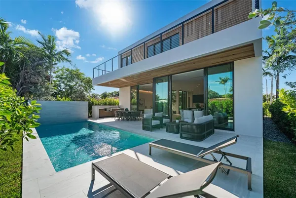 a patio with table and chairs and potted plants