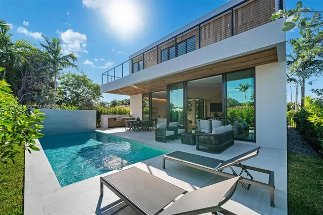 a patio with table and chairs and potted plants