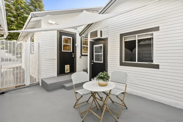 a backyard of a house with table and chairs