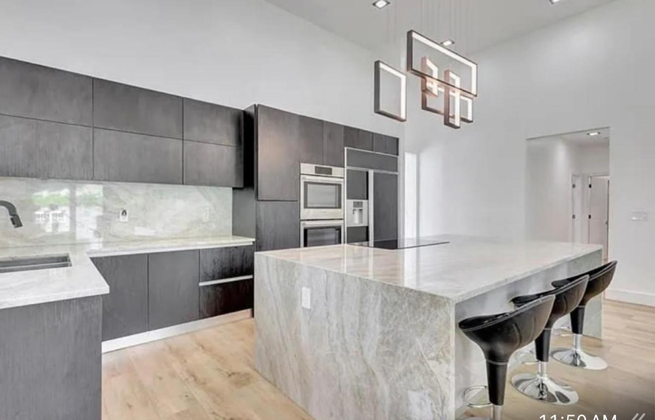 2299 Northwest 55th Street Boca Raton, FL 33496 - Photo 11 of 47 a kitchen with kitchen island a counter top space a sink stainless steel appliances and cabinets