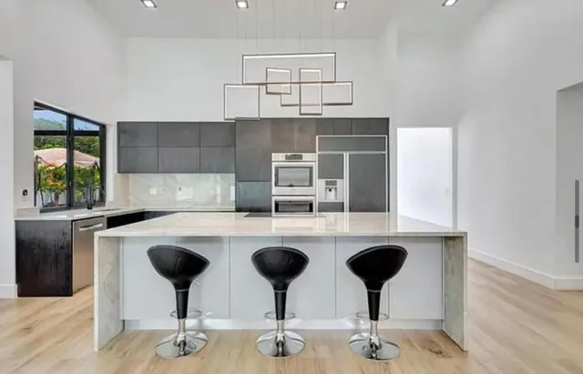 a kitchen with cabinets and chairs