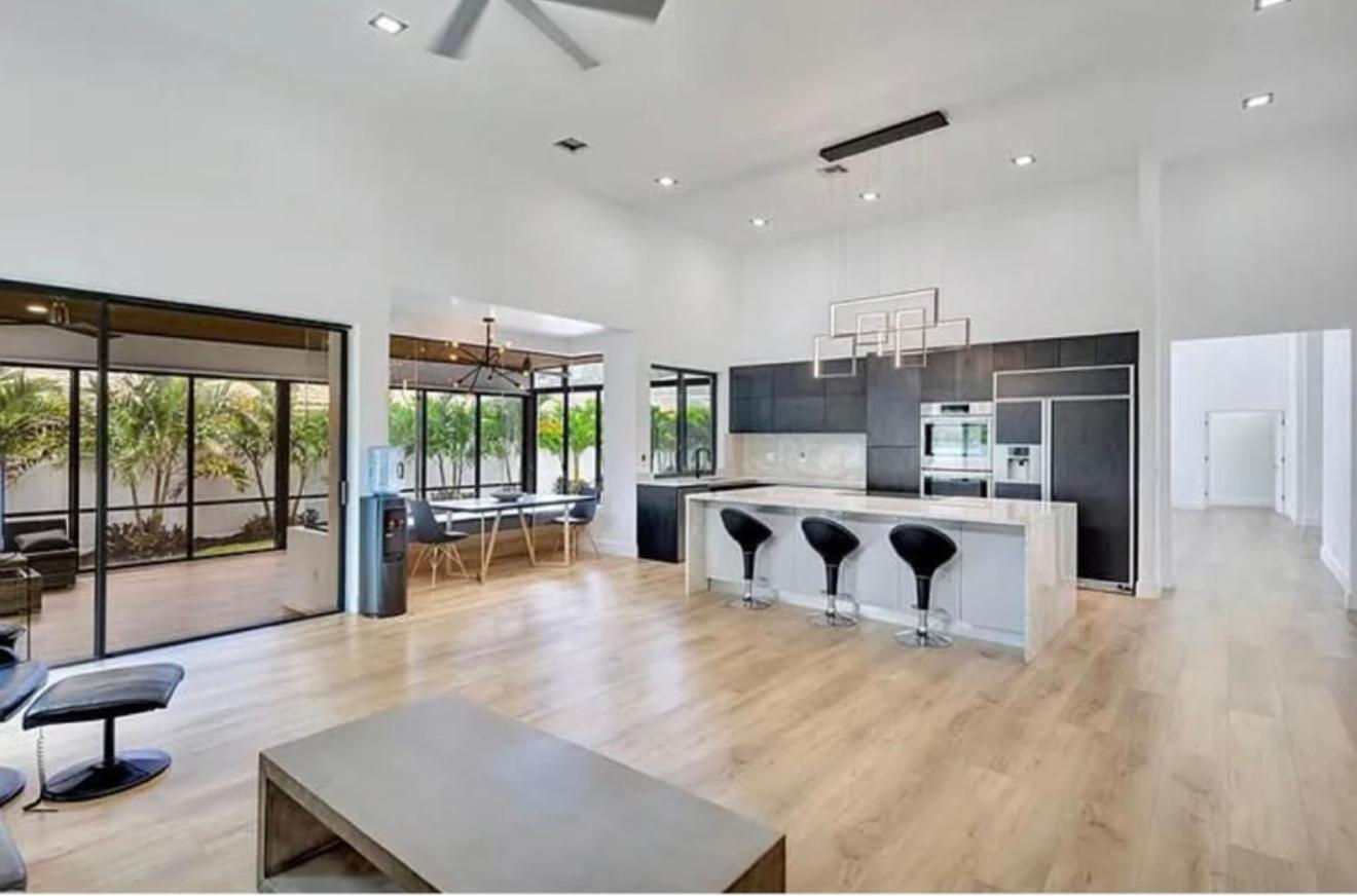 2299 Northwest 55th Street Boca Raton, FL 33496 - Photo 14 of 47 a large kitchen with stainless steel appliances large windows a large counter top and a view of living room
