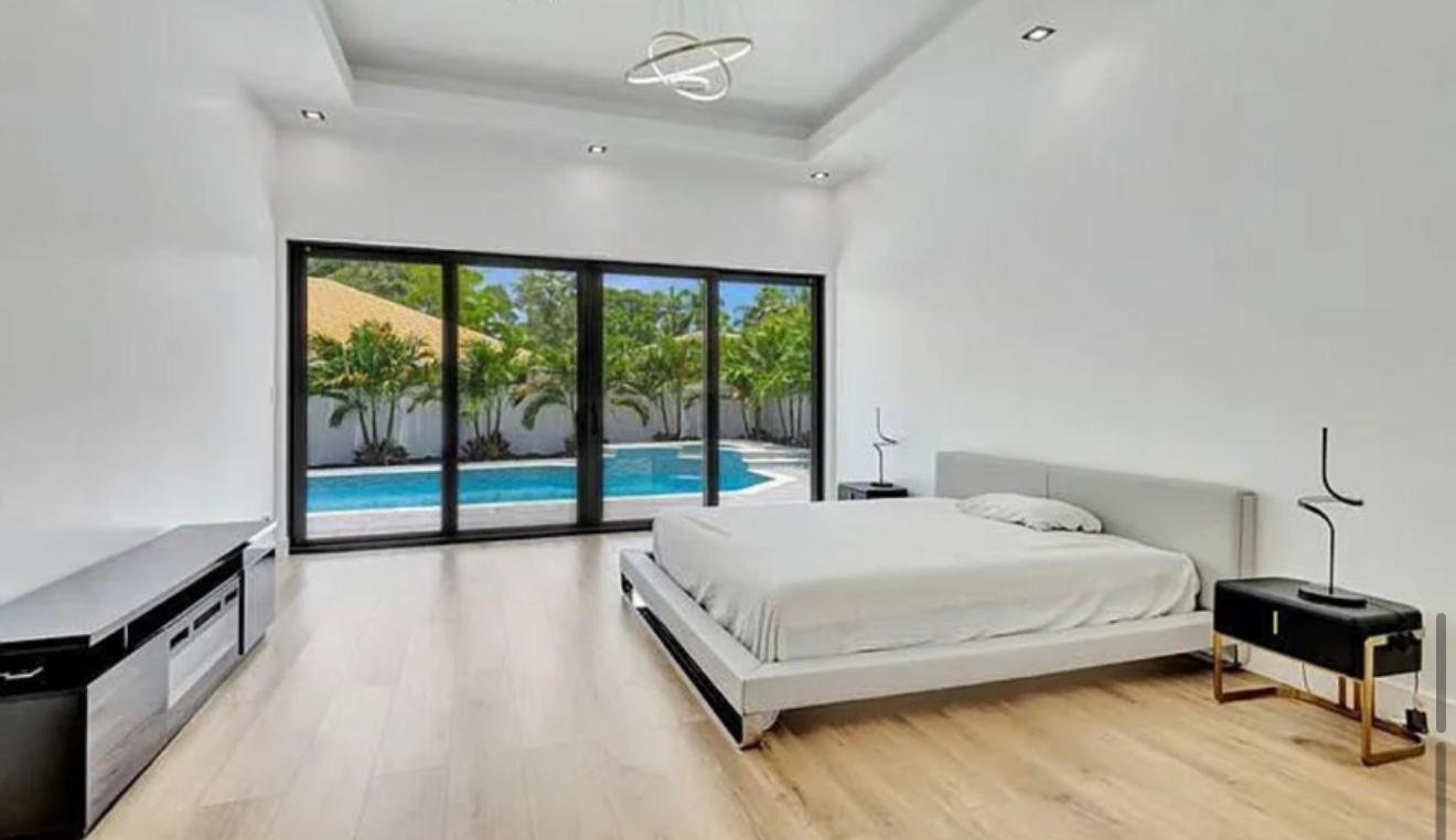 2299 Northwest 55th Street Boca Raton, FL 33496 - Photo 17 of 47 a bedroom with a bed and a large window