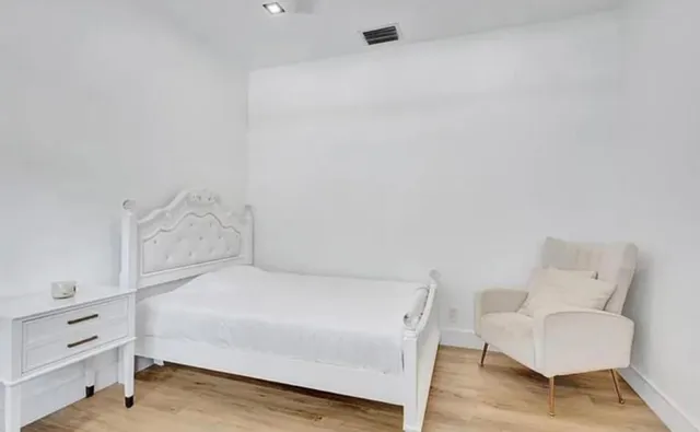 a bedroom with a bed and a chair