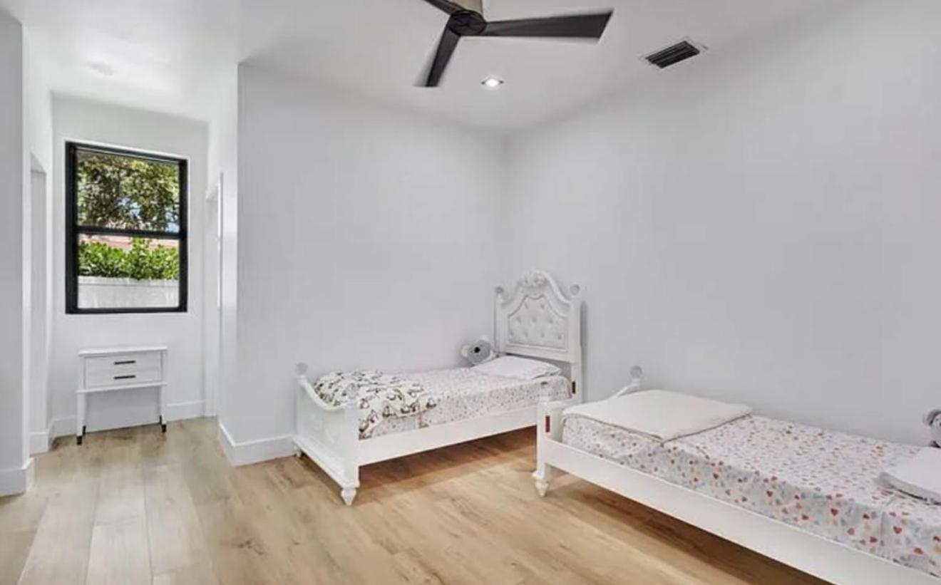 2299 Northwest 55th Street Boca Raton, FL 33496 - Photo 27 of 47 a bedroom with a bed and wooden floor