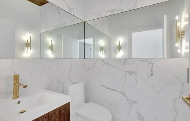 a bathroom with a sink vanity mirror and toilet