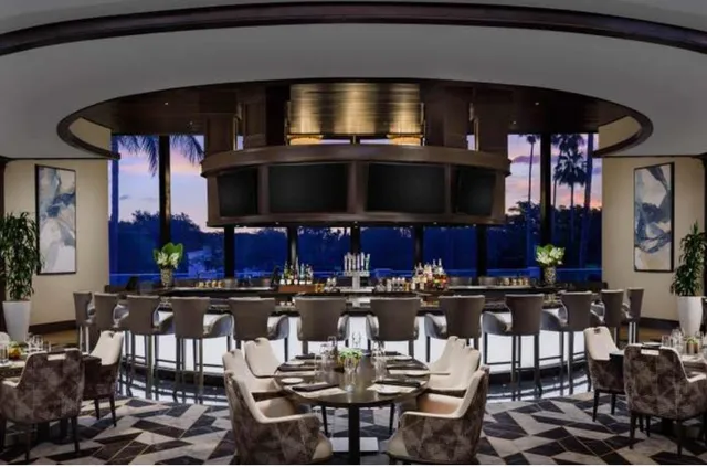 a kitchen area with stainless steel appliances a dining table and chairs
