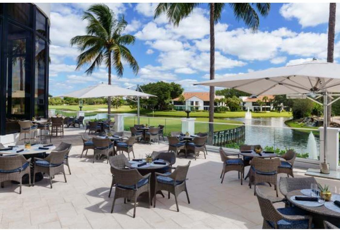 2299 Northwest 55th Street Boca Raton, FL 33496 - Photo 46 of 47 a view of a patio with couches and table and chairs under an umbrella