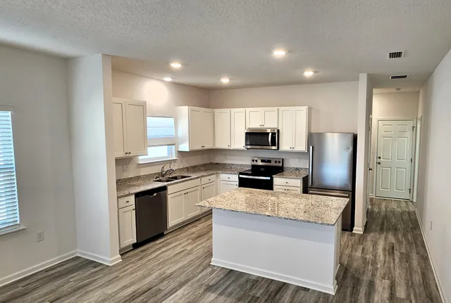 a kitchen with stainless steel appliances granite countertop a refrigerator stove microwave and sink