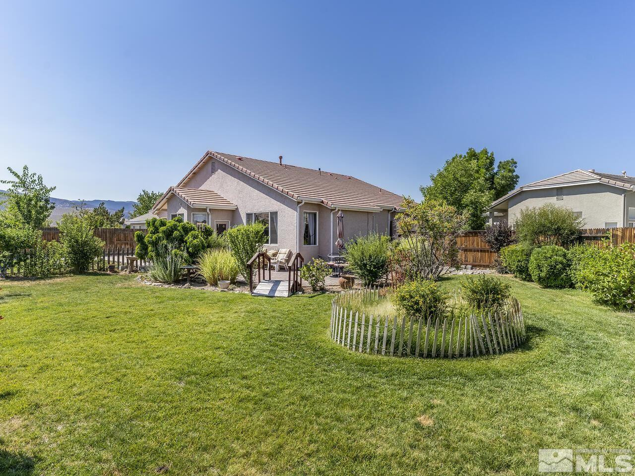 10150 Robilee Court Reno, NV 89521 - Photo 12 of 40 a view of a big house with a big yard potted plants and large tree