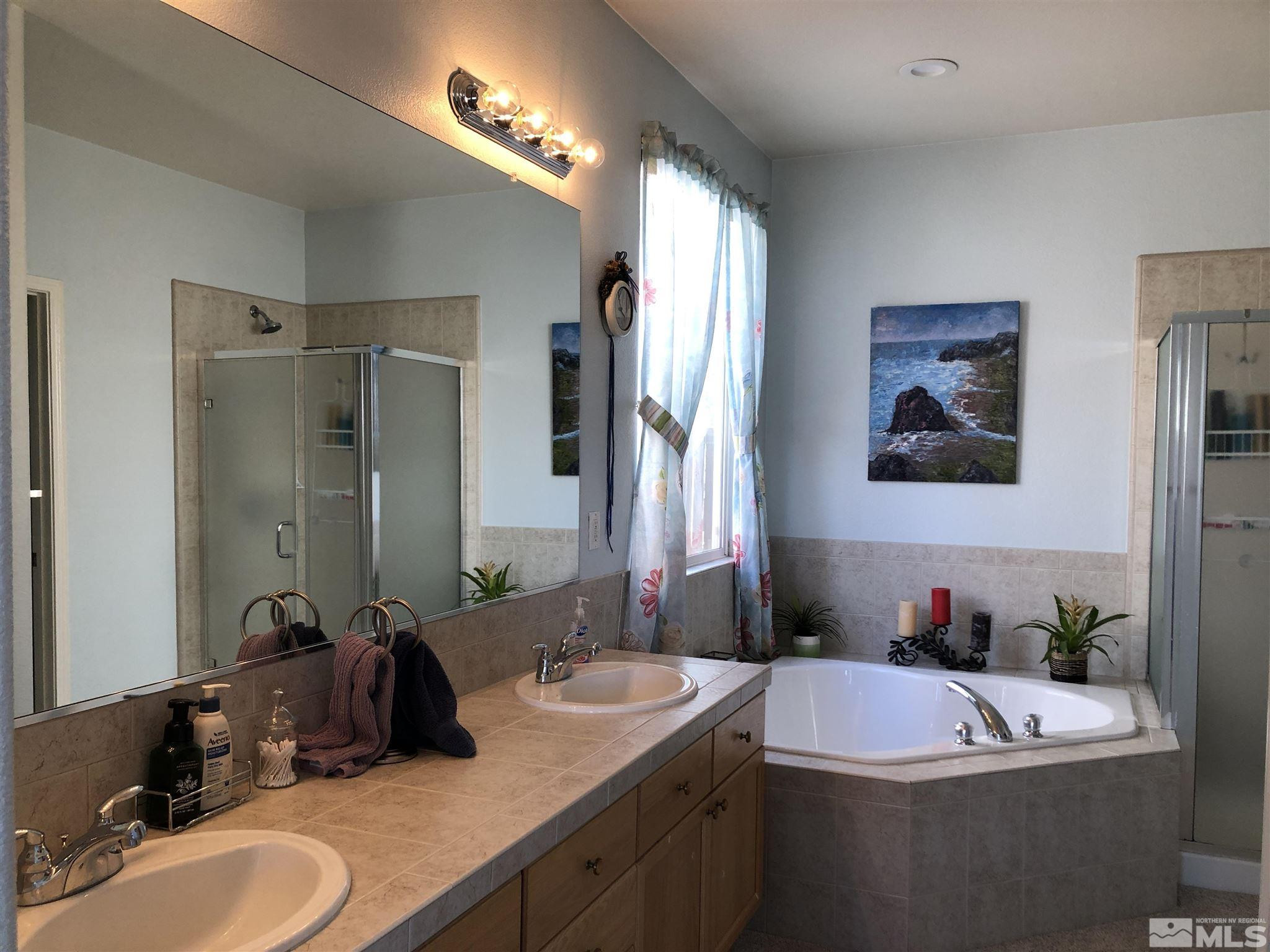 10150 Robilee Court Reno, NV 89521 - Photo 19 of 40 a bathroom with a double vanity sink tub and mirror