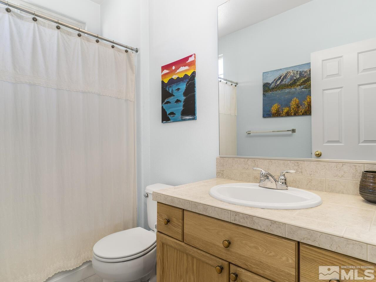 10150 Robilee Court Reno, NV 89521 - Photo 26 of 40 a bathroom with a toilet a sink and a mirror