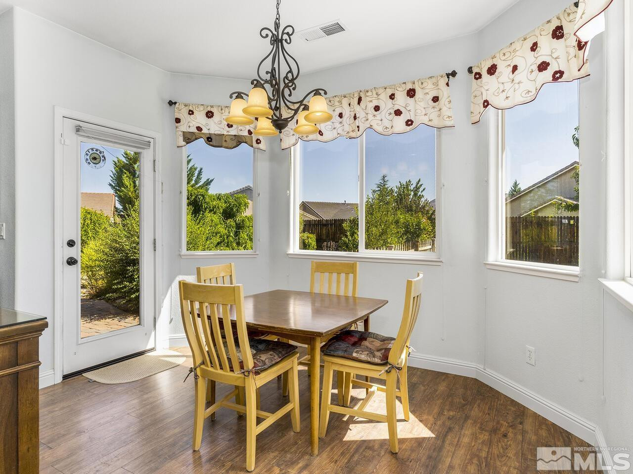 10150 Robilee Court Reno, NV 89521 - Photo 5 of 40 a view of a dining room with furniture a chandelier and wooden floor