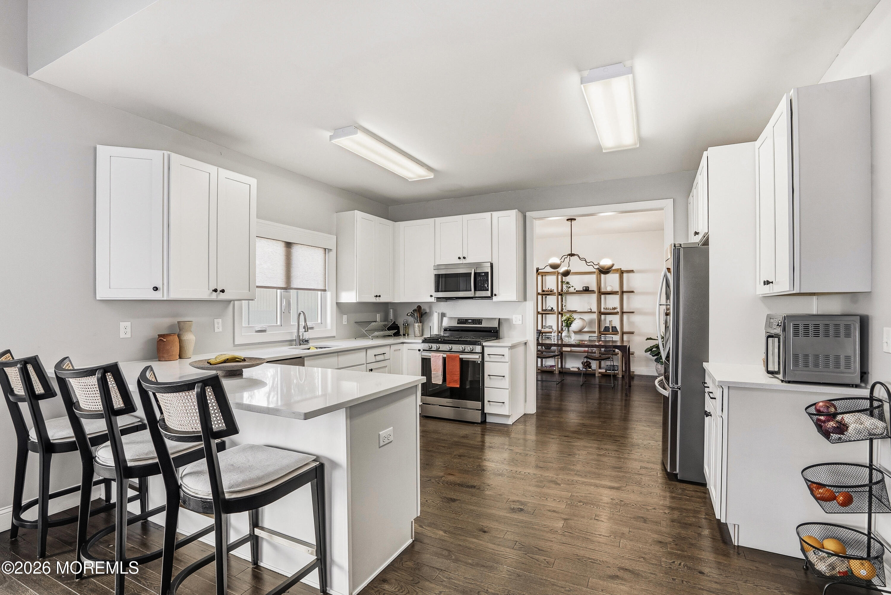 127 West 2nd Street Howell, NJ 07731 - Photo 8 of 29 a kitchen with stainless steel appliances a table chairs refrigerator and a stove top oven