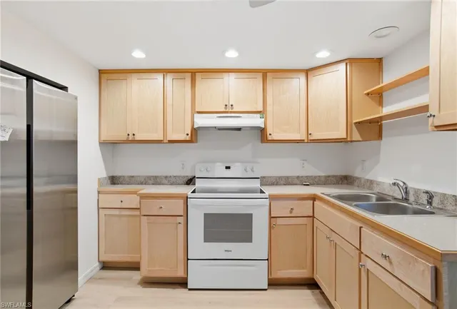 a kitchen with white cabinets stainless steel appliances and sink