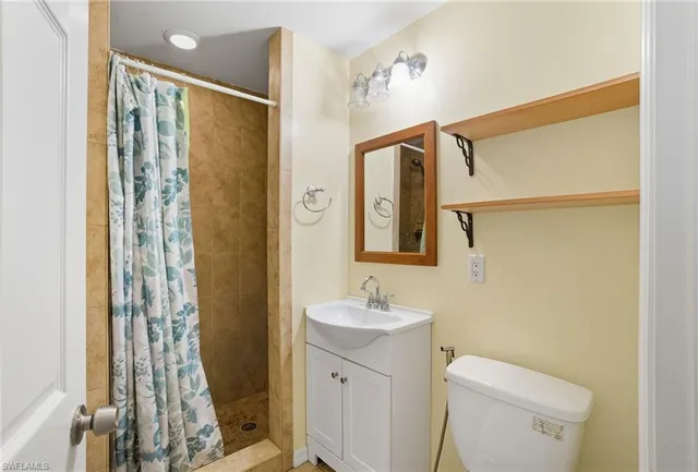a bathroom with a shower a sink and a mirror