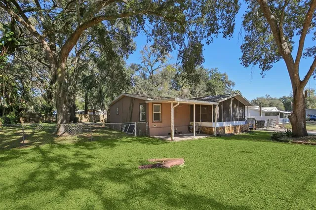 a front view of a house with a yard and trees
