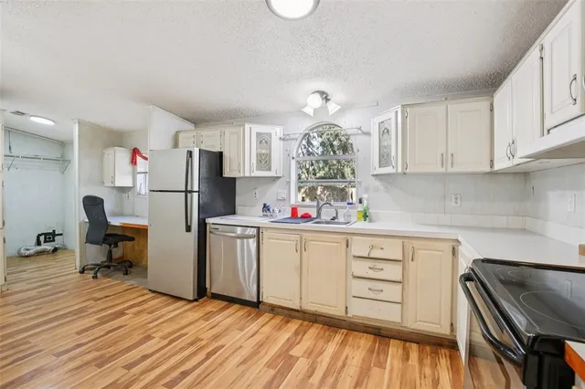 a kitchen with stainless steel appliances a refrigerator sink and cabinets