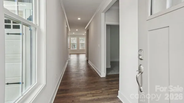 a view of a hallway with wooden floor and staircase