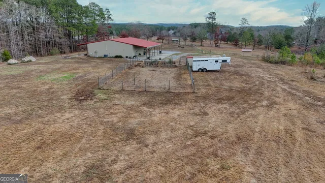 a view of a dry yard with wooden fence