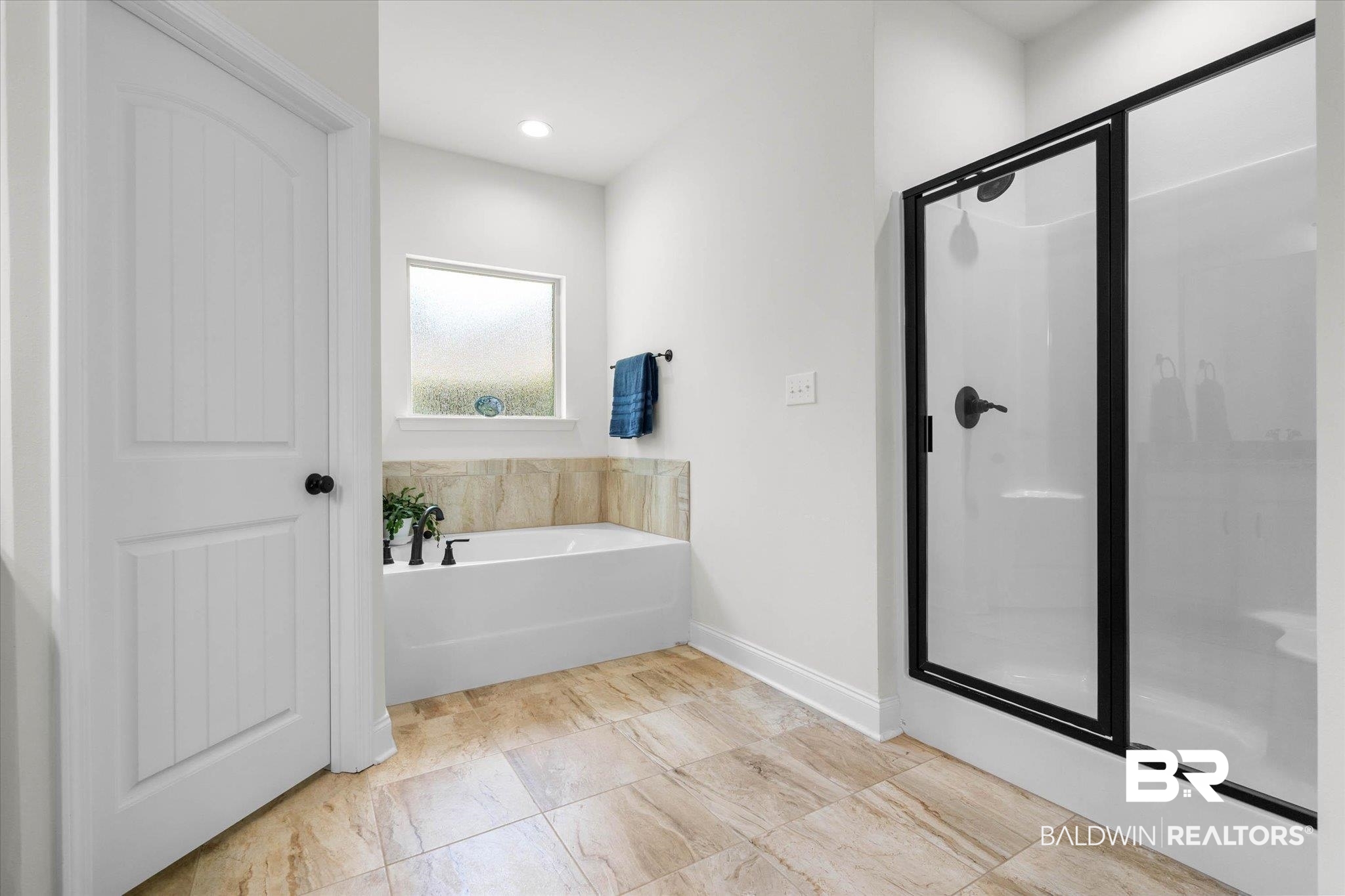 1270 Surrey Loop Foley, AL 36535 - Photo 16 of 27 Bathroom featuring a soaking tub with tile surround, a separate shower with a black-framed glass enclosure, and large format tile flooring