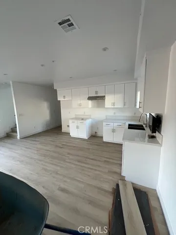 a room with wooden floor and cabinets