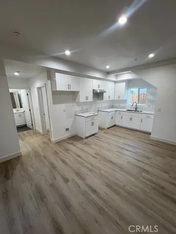 a large kitchen with a lot of counter space and wooden floor