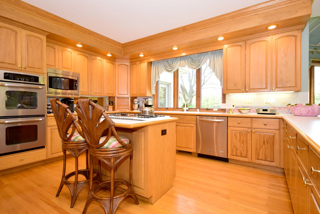 316 Trinity Lane Oak Brook, IL 60523 - Photo 8 of 25 a kitchen with stainless steel appliances kitchen island granite countertop a table chairs sink and cabinets