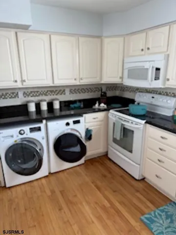 a kitchen with granite countertop a white cabinets a sink and dishwasher with wooden floor
