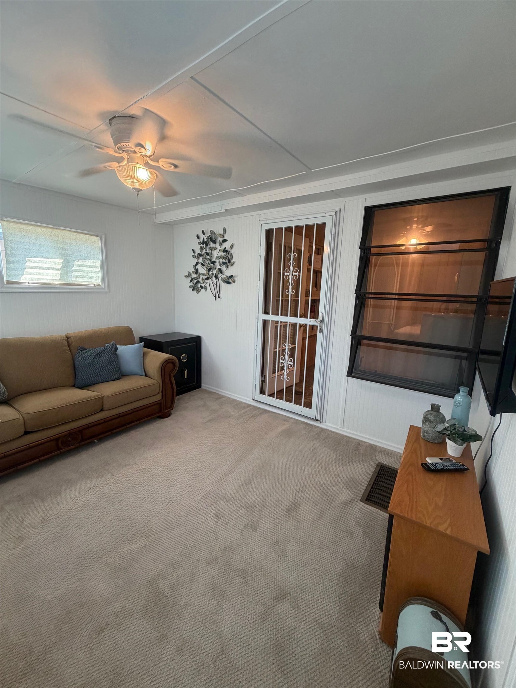 685 Escambia Loop Lillian, AL 36549 - Photo 17 of 43 Living area with a ceiling fan, carpet flooring, and wooden walls
