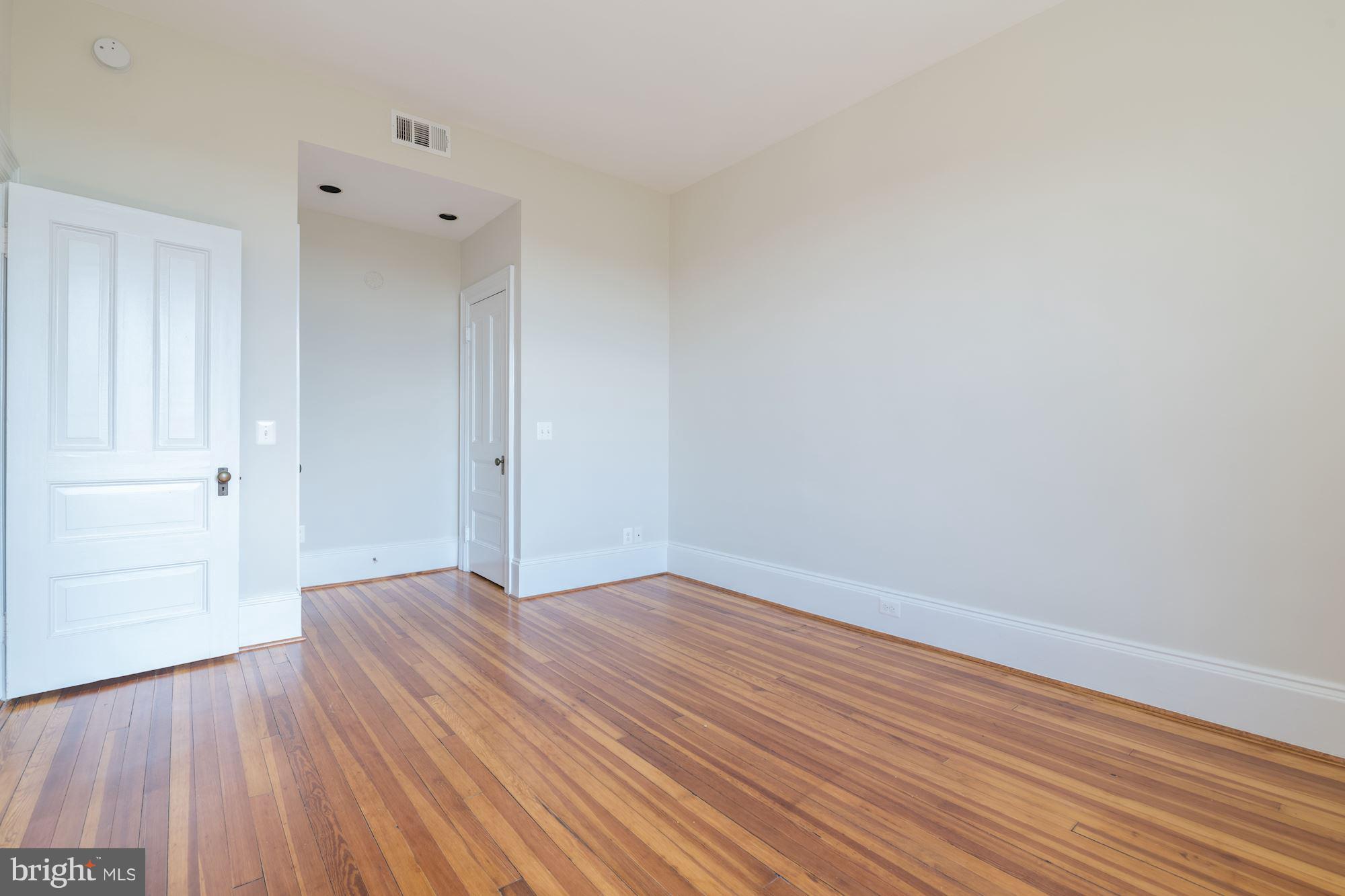 2853 Ontario Road Northwest, Unit 505 Washington, DC 20009 - Photo 21 of 29 a view of an empty room with wooden floor