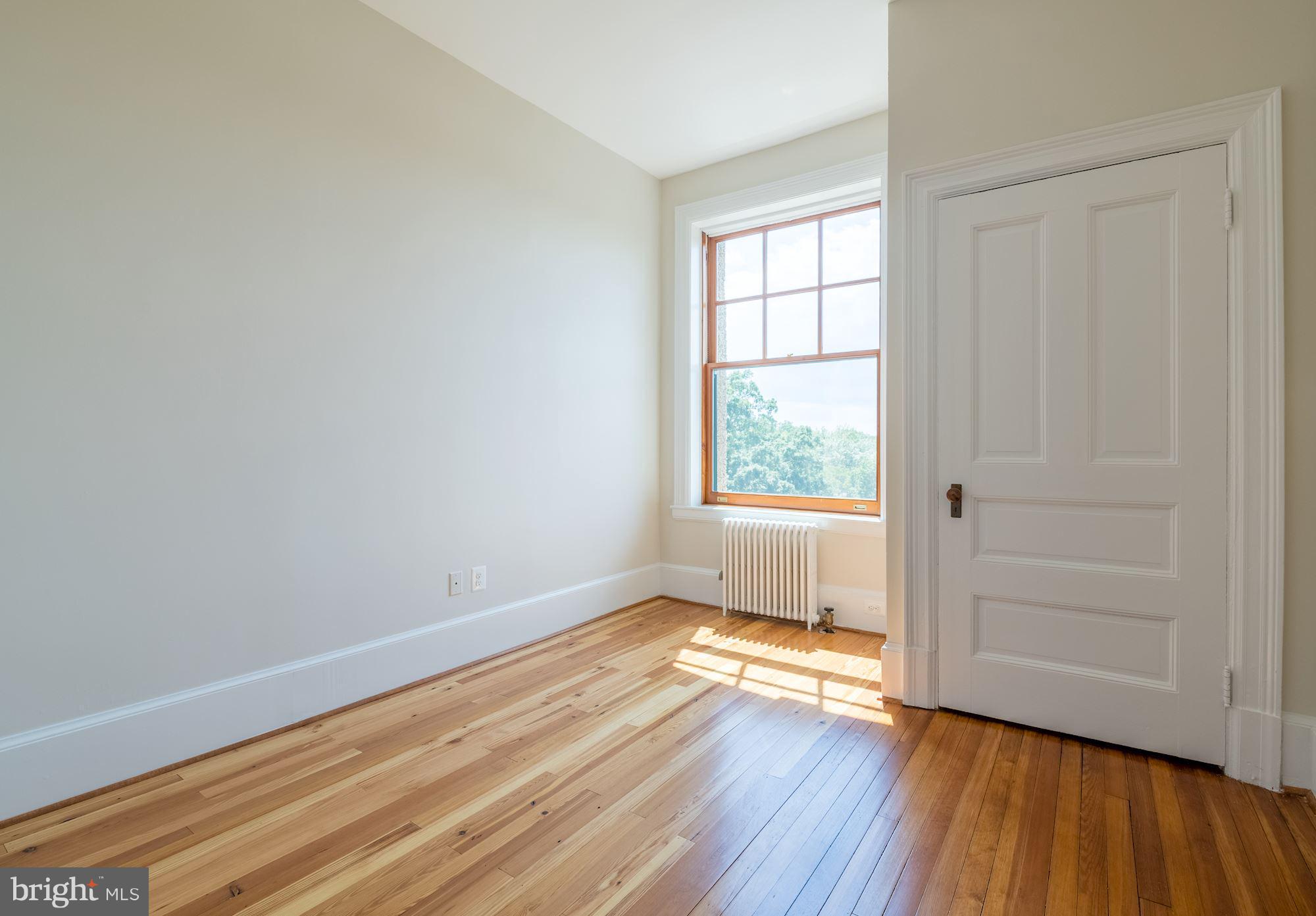 2853 Ontario Road Northwest, Unit 505 Washington, DC 20009 - Photo 23 of 29 an empty room with wooden floor and windows