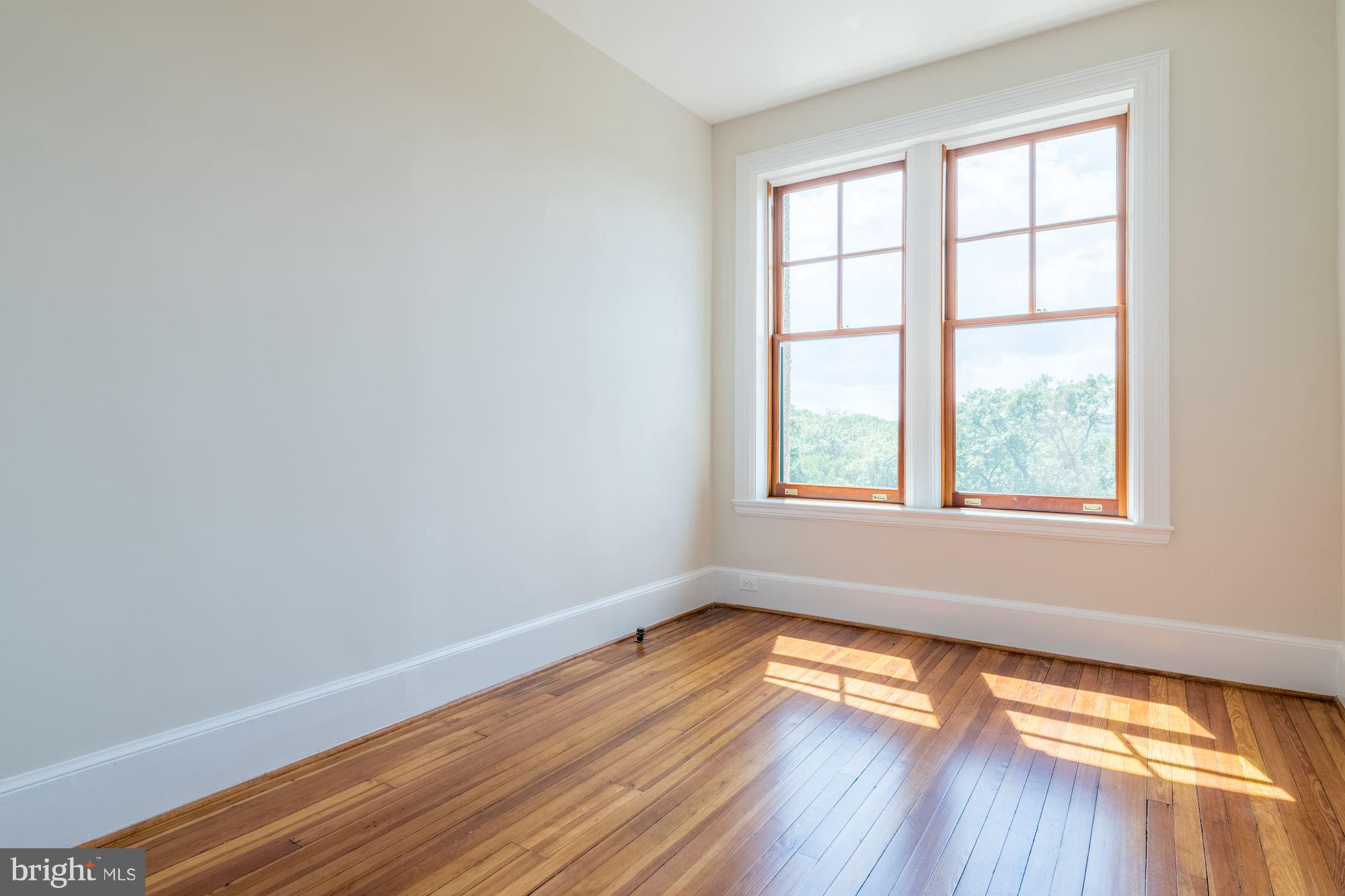 2853 Ontario Road Northwest, Unit 505 Washington, DC 20009 - Photo 24 of 29 an empty room with wooden floor and windows